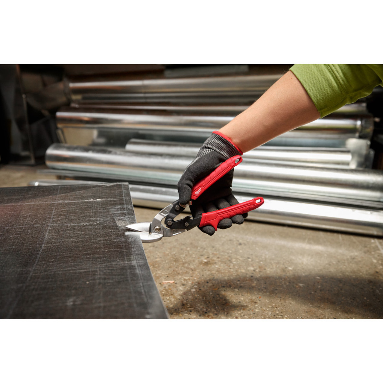 Milwaukee 48-22-4542 18GA Left Offset Snips showing in use cutting through sheet metal Milwaukee 48-22-4542 18GA Left Offset Snips showing in use cutting through sheet metal