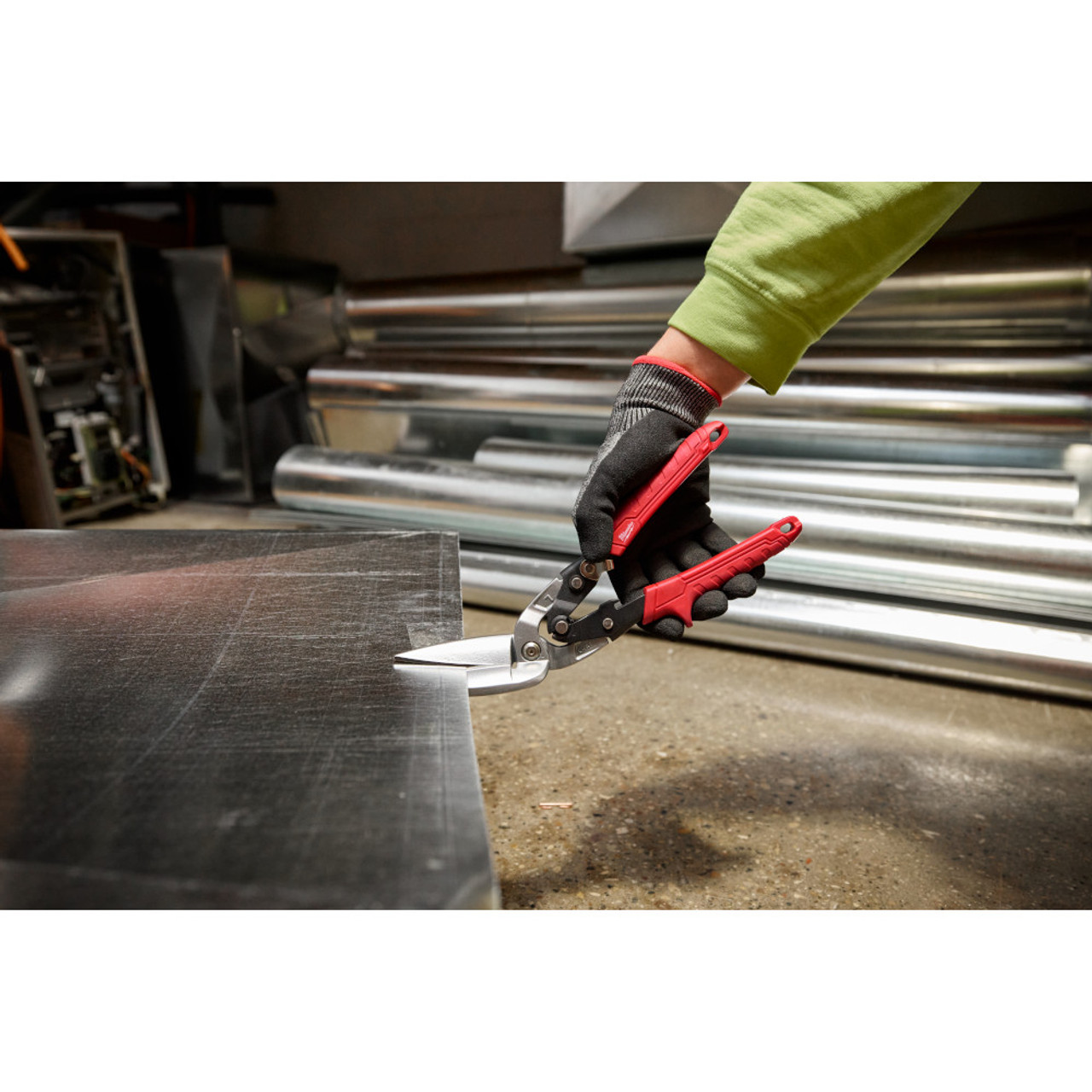 Milwaukee 48-22-4568 18GA Left Long Offset Snips showing in use cutting through sheet metal Milwaukee 48-22-4568 18GA Left Long Offset Snips showing in use cutting through sheet metal