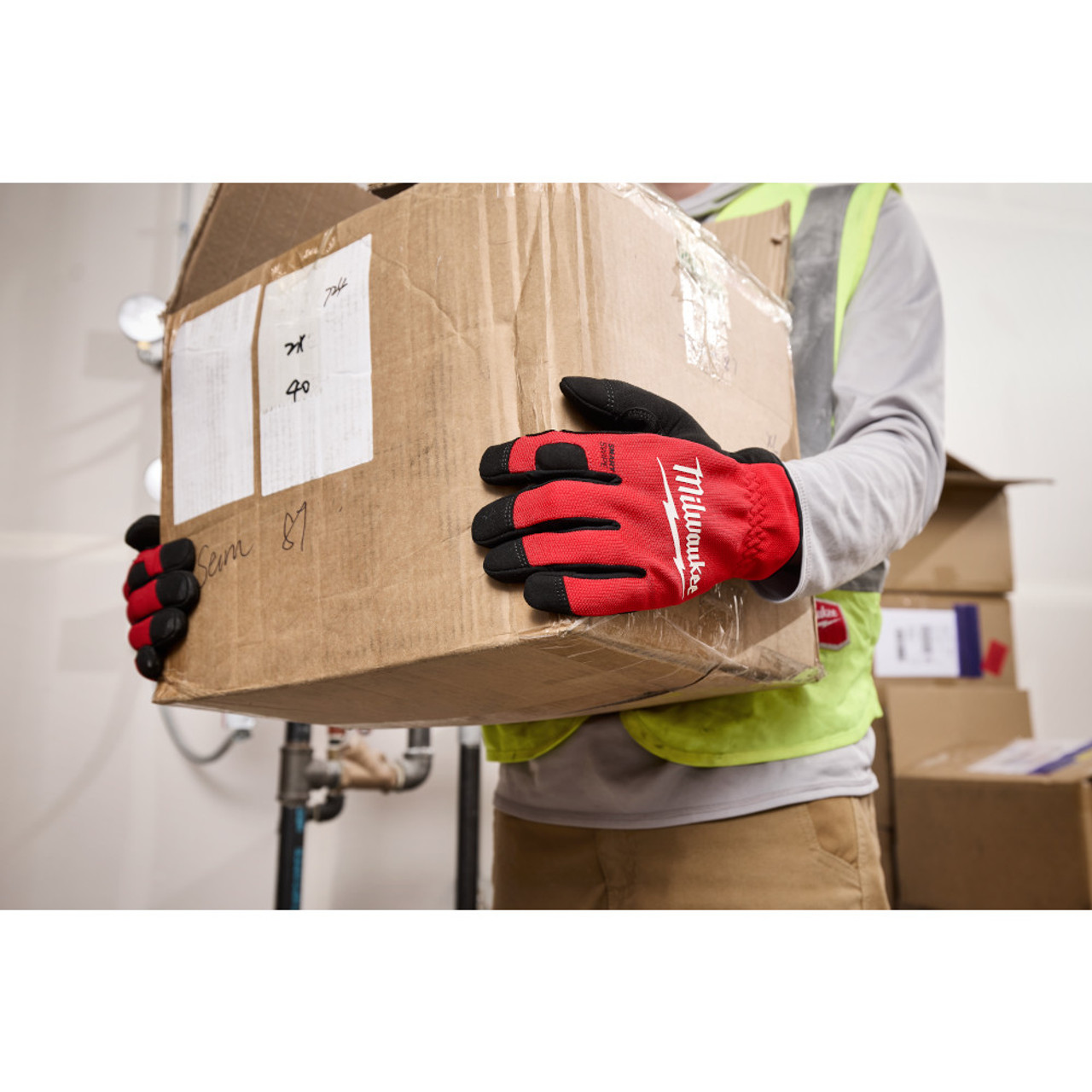 Milwaukee 48-73-8511 Lightweight Work Gloves - M showing gloves being worn while carrying a box