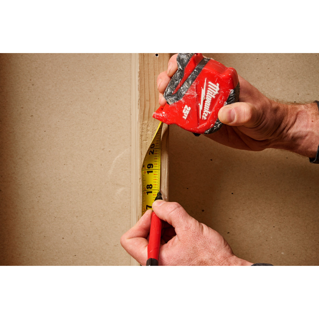 Milwaukee 48-22-1725 25ft Compact Tape Measure showing in use measuring and marking a stud Milwaukee 48-22-1725 25ft Compact Tape Measure showing in use measuring and marking a stud