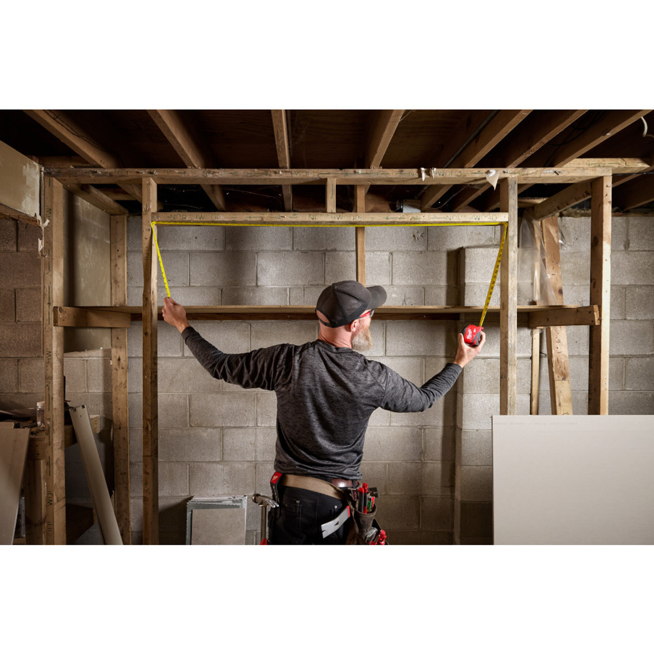 Milwaukee 48-22-1726 26ft/8m Compact Tape Measure showing in use measuring an opening between studs Milwaukee 48-22-1726 26ft/8m Compact Tape Measure showing in use measuring an opening between studs