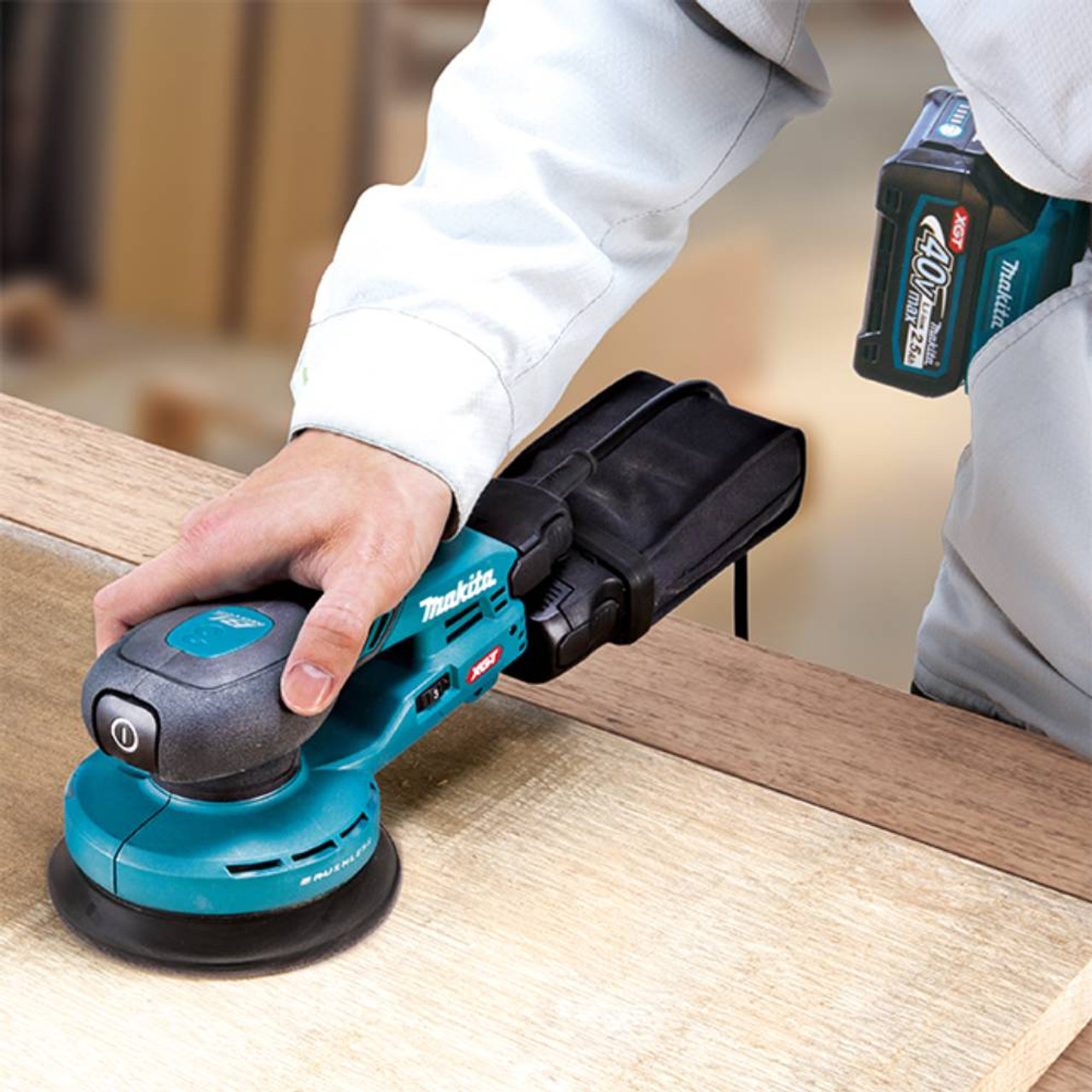 Makita BO002CGZ 40V XGT Brushless 6in Random Orbit Sander (Tool Only) showing in use sanding a wood panel Makita BO002CGZ 40V XGT Brushless 6in Random Orbit Sander (Tool Only) showing in use sanding a wood panel