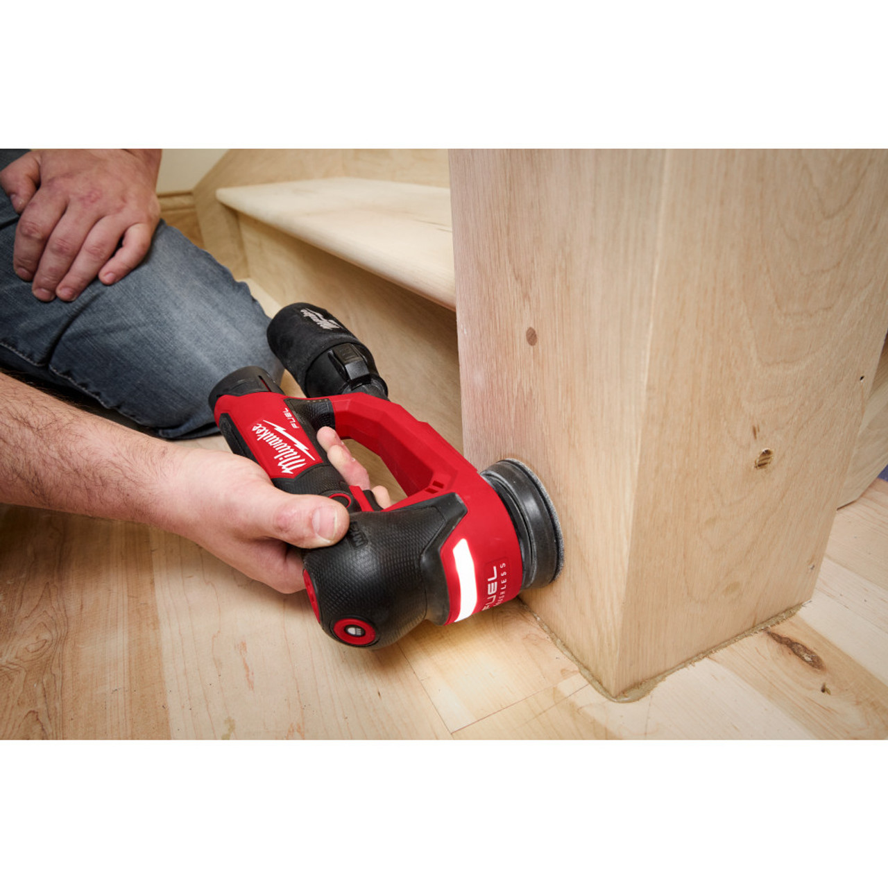 Milwaukee 2535-20 12V FUEL 3in Random Orbital Detail Sander (Tool Only) showing in use sanding stair railing post (Battery Sold Separately)