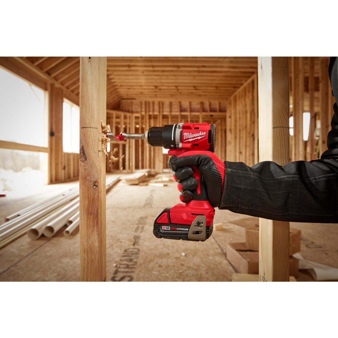 Milwaukee 3601-20 M18 Compact Brushless 1/2in Drill/ Driver Kit showing in use drilling a hole in a wood stud