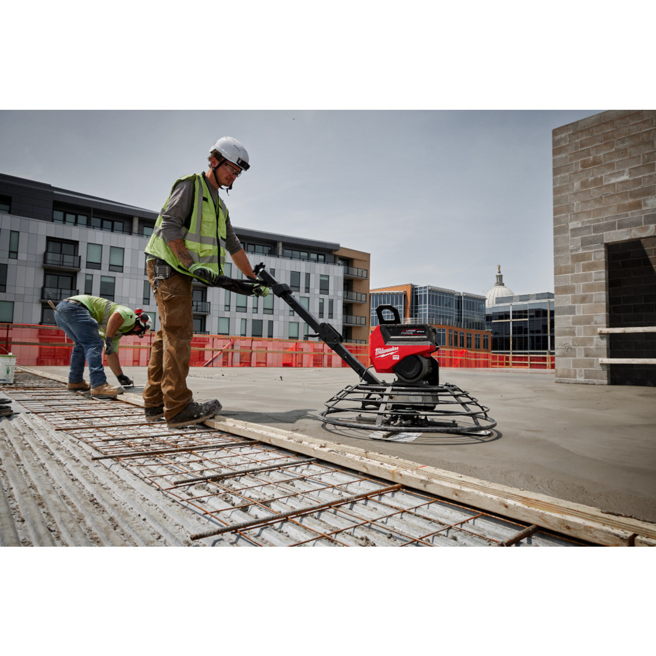 Milwaukee MXF336-3HD MX FUEL 36in Walk-Behind Edging Trowel Kit showing in use finish a concrete floor outside a building