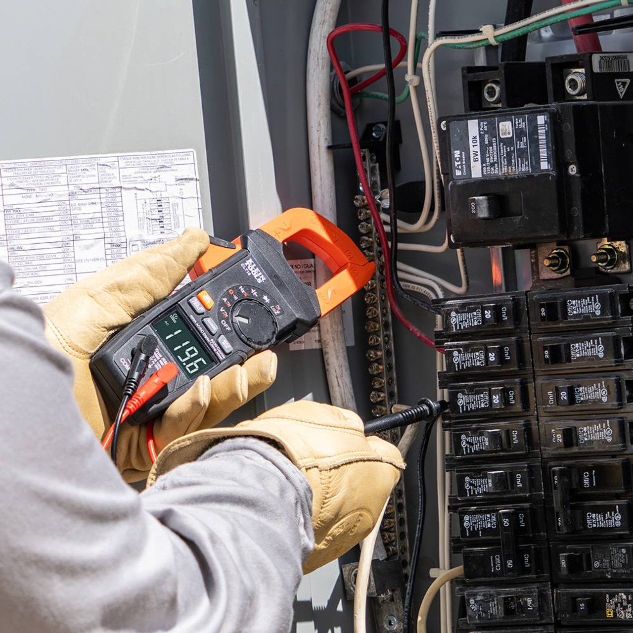 Klein Tools CL710 600 Amp AC/DC Auto-Ranging Digital Pro Clamp Meter showing in use  measuring electrical elements with leads