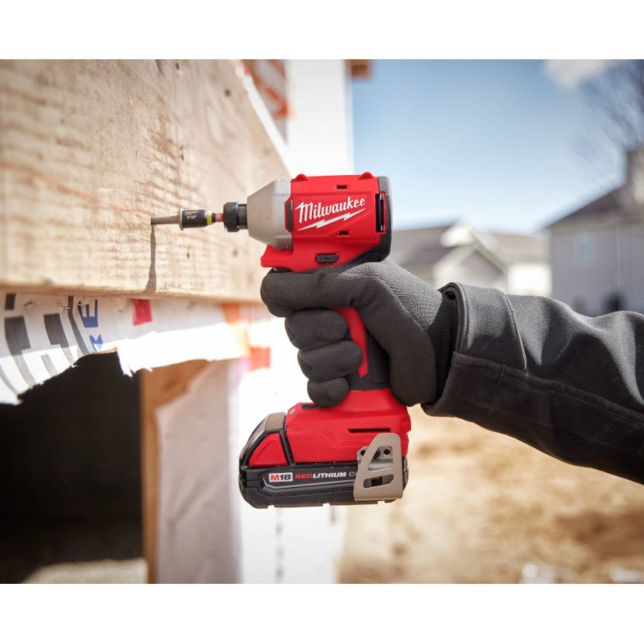 Milwaukee 3693-22CX M18 2-Tool Cordless Brushless Compact 1/2 inch Hammer Drill/Driver & 1/4 inch Hex 3-Speed Impact Driver Combo Kit showing in use driving a screw into a wood stud