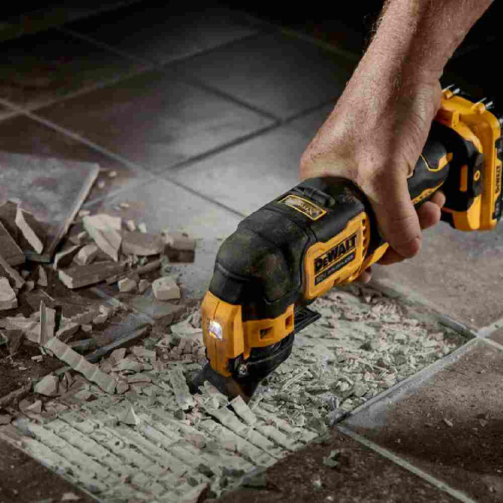 DeWalt DCS353G1 XTREME 12V MAX Cordless Brushless Oscillating Multi Tool Kit  showing in use cutting and grinding concrete under tile