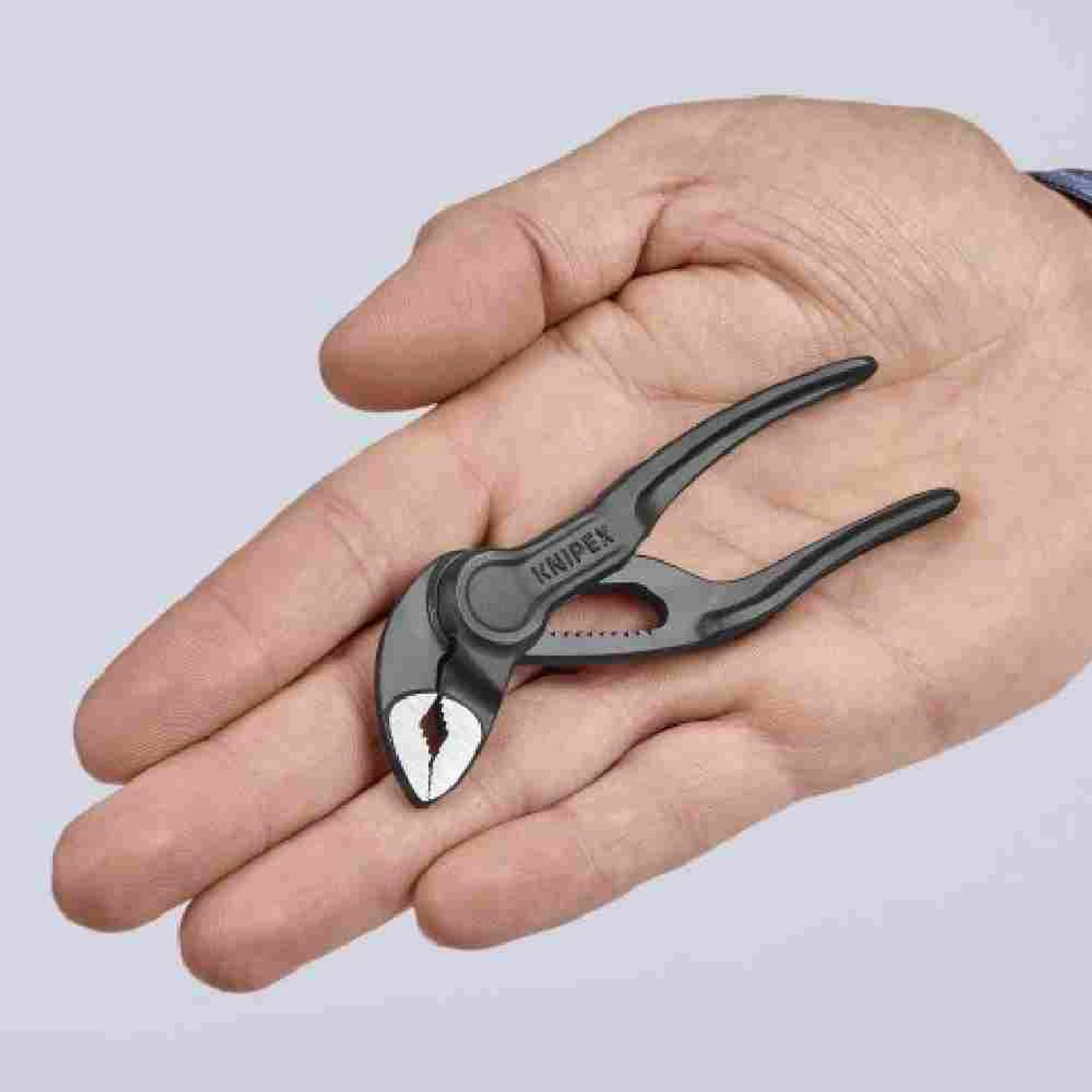 Knipex 8700100SBA 4 inch Cobra XS Water Pump Pliers showing in hand for size Knipex 8700100SBA 4 inch Cobra XS Water Pump Pliers showing in hand for size