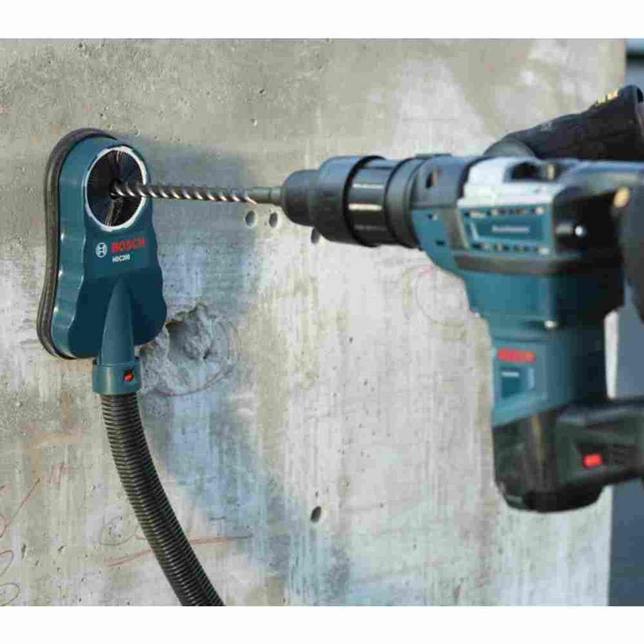 Bosch HDC200 Universal Dust Collection Attachment showing in use drilling hole into concrete wall with drill (Sold Separately) Bosch HDC200 Universal Dust Collection Attachment showing in use drilling hole into concrete wall with drill (Sold Separately)