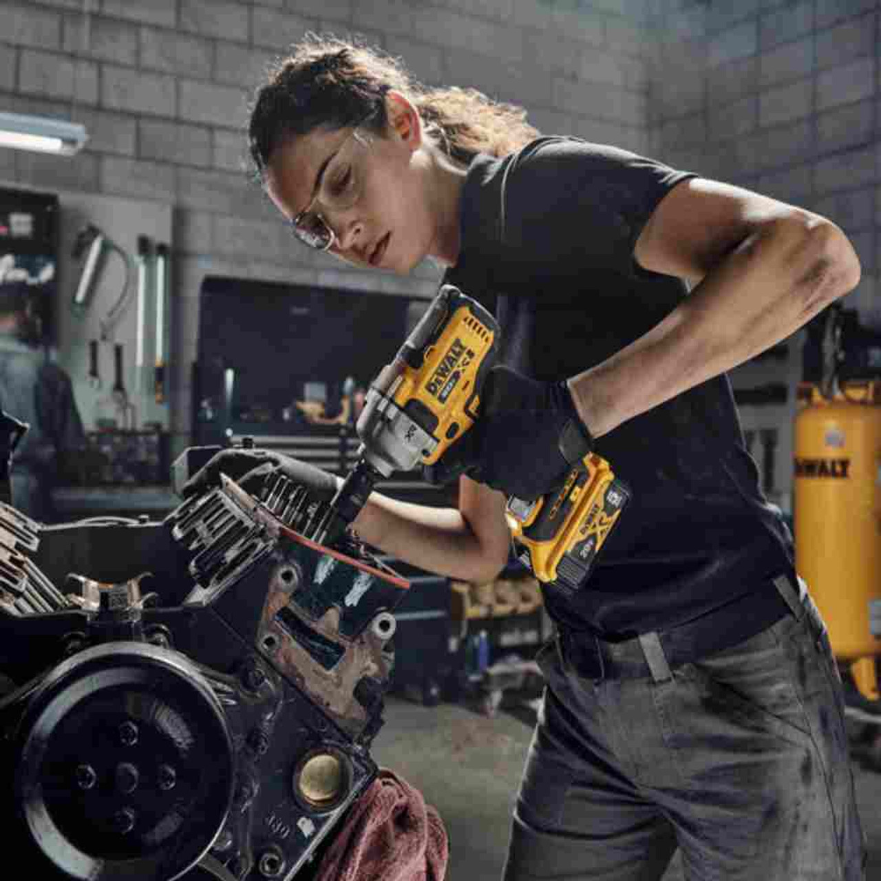 DeWalt DCF892B 20V MAX XR Cordless Mid-Range 1/2 inch Impact Wrench with Detent Pin Anvil (Tool Only) showing in use working on a vehicle motor