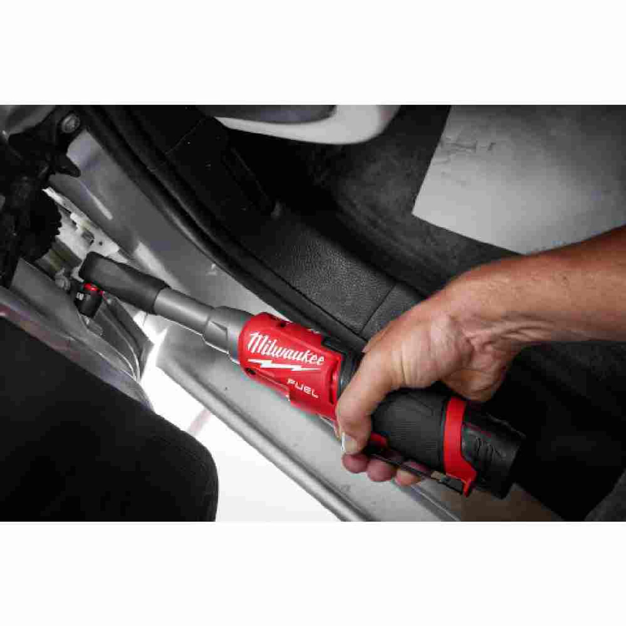 Milwaukee 2569-20 M12 FUEL Cordless Brushless 3/8 inch Extended Reach High Speed Ratchet (Tool Only) showing in use fastening bolt to a vehicle (Battery and socket sold separately) Milwaukee 2569-20 M12 FUEL Cordless Brushless 3/8 inch Extended Reach High Speed Ratchet (Tool Only) showing in use fastening bolt to a vehicle (Battery and socket sold separately)