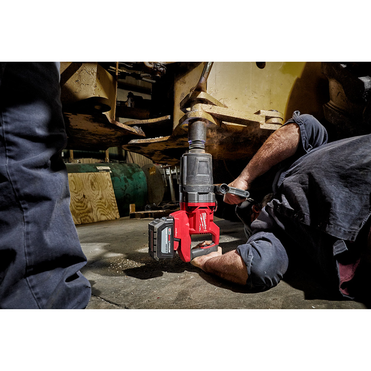 Milwaukee 2868-22HD M18 FUEL Cordless Brushless D-Handle High Torque 1 inch Impact Wrench Kit showing in use fastening bolt onto piece of heavy duty equipment