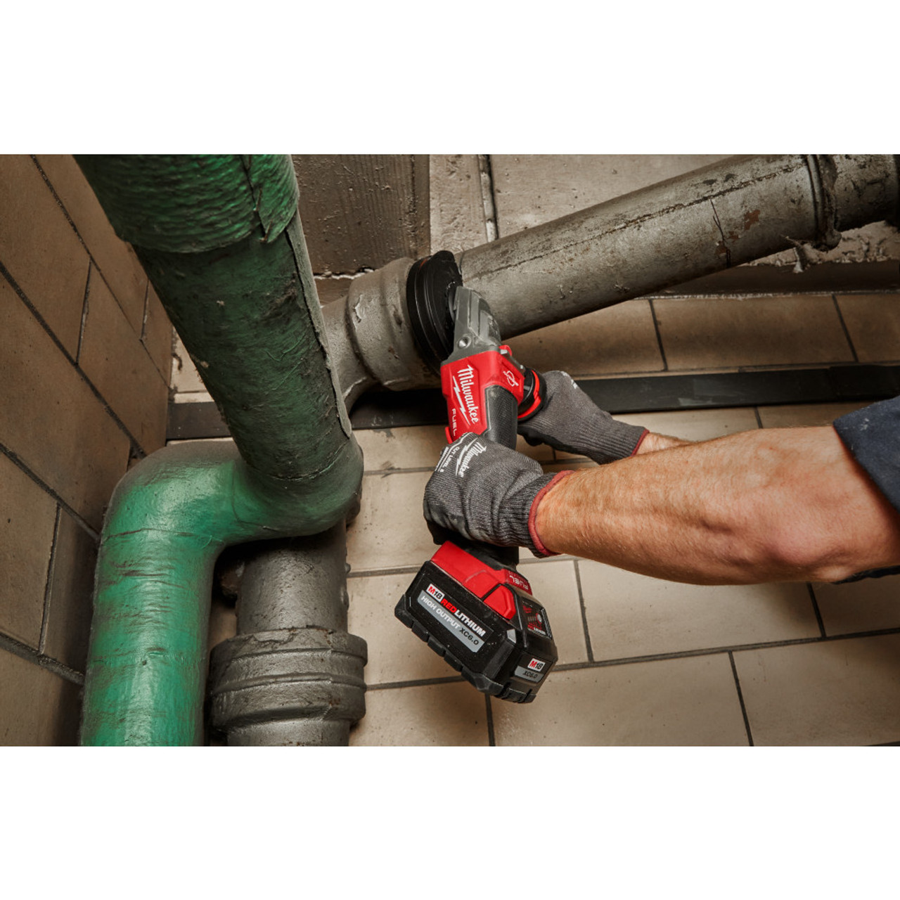 Milwaukee 2886-20 M18 FUEL Cordless Brushless 5 inch Flathead Braking Grinder with Paddle Switch No-Lock (Tool Only) showing in use cutting metal pipe Milwaukee 2886-20 M18 FUEL Cordless Brushless 5 inch Flathead Braking Grinder with Paddle Switch No-Lock (Tool Only) showing in use cutting metal pipe