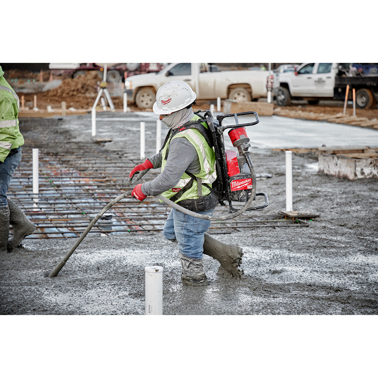 Milwaukee MXF371-2XC MX FUEL Cordless Brushless Backpack Concrete Vibrator Kit showing in use vibrating a slab of concrete