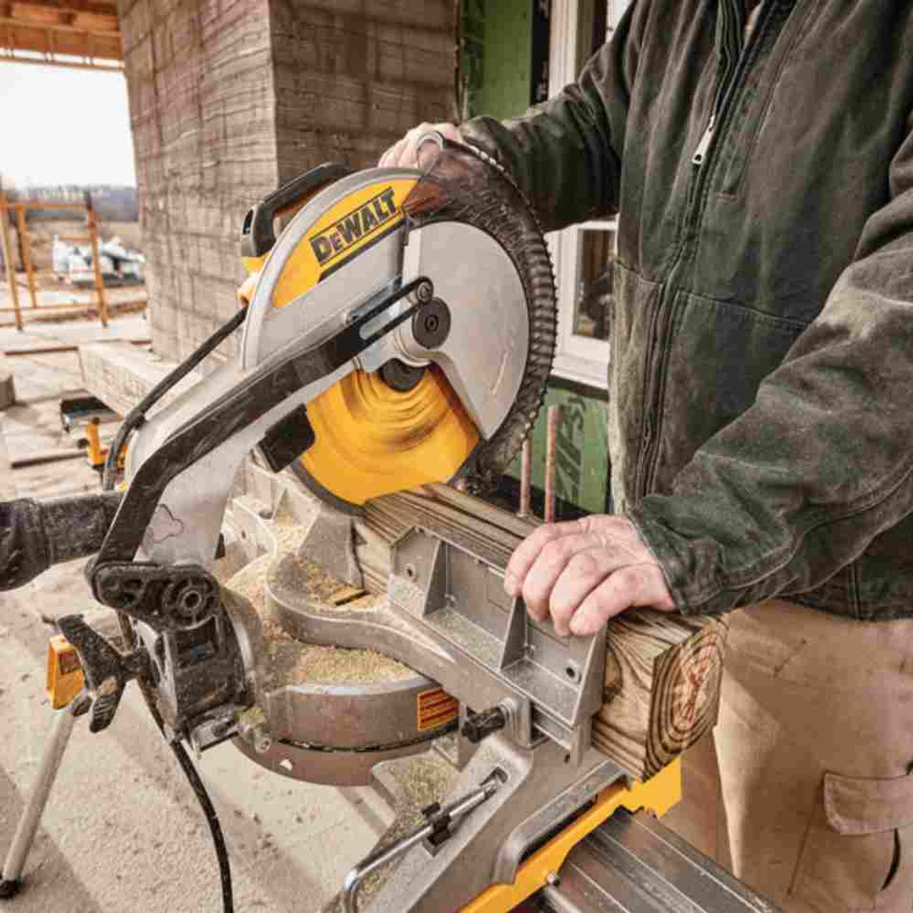DeWalt DWS715 15 Amp 12 inch Single-Bevel Compound Mitre Saw showing in use cutting a four by four showing from the back side