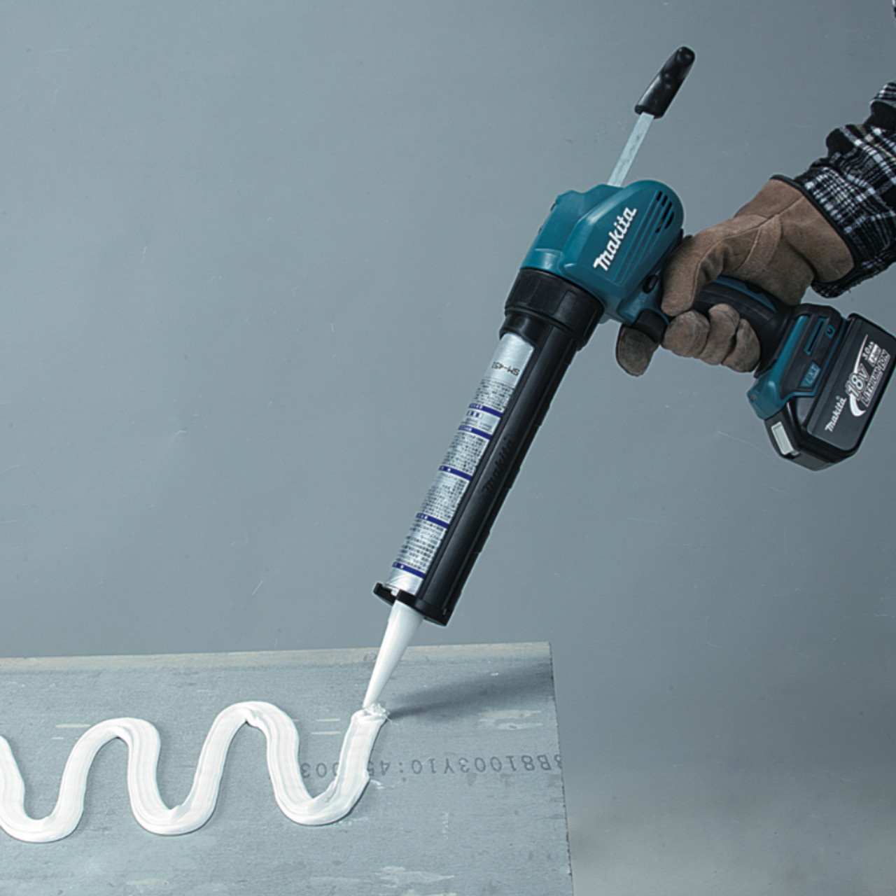 Makita DCG180ZB 18V Cordless 600ml Caulking Gun (Tool Only) showing in use gluing pexi-glass panel