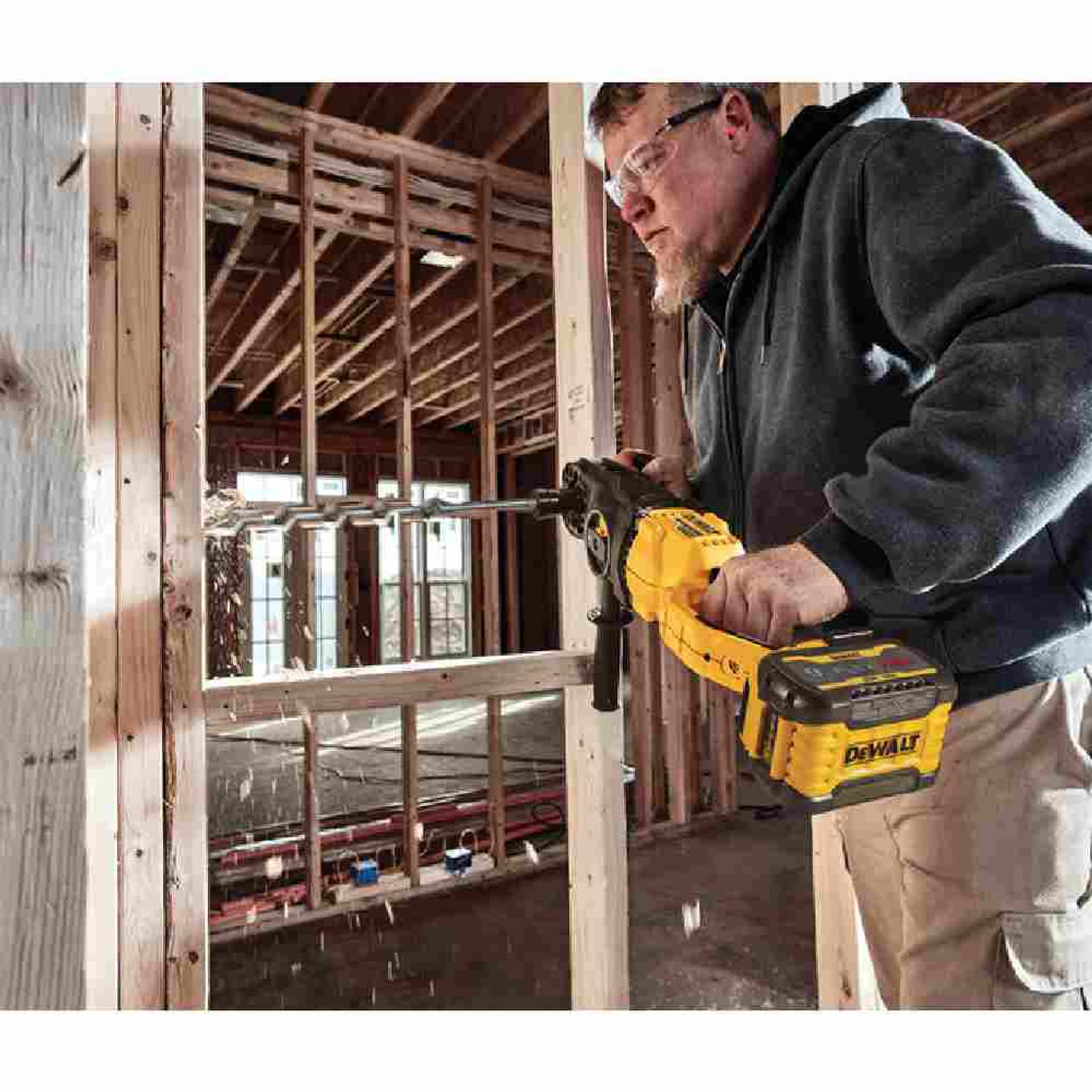 DeWalt DCD471X1 60V MAX Cordless Brushless Quick Change Stud & Joist Drill with E-Clutch Kit showing  in use frilling through laminated lumber in wooden wall DeWalt DCD471X1 60V MAX Cordless Brushless Quick Change Stud & Joist Drill with E-Clutch Kit showing  in use frilling through laminated lumber in wooden wall