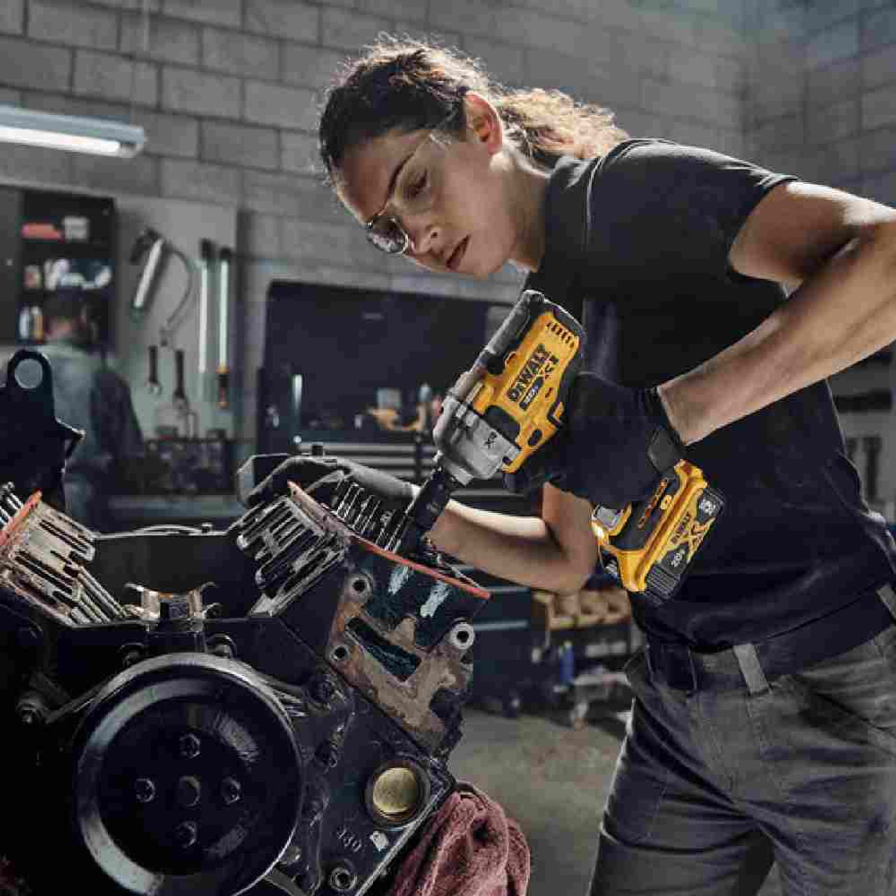 DeWalt DCF891P2 20V MAX XR Cordless Mid-Range 1/2 inch Impact Wrench with Hog Ring Kit showing in use fastening bolts inside motor housing