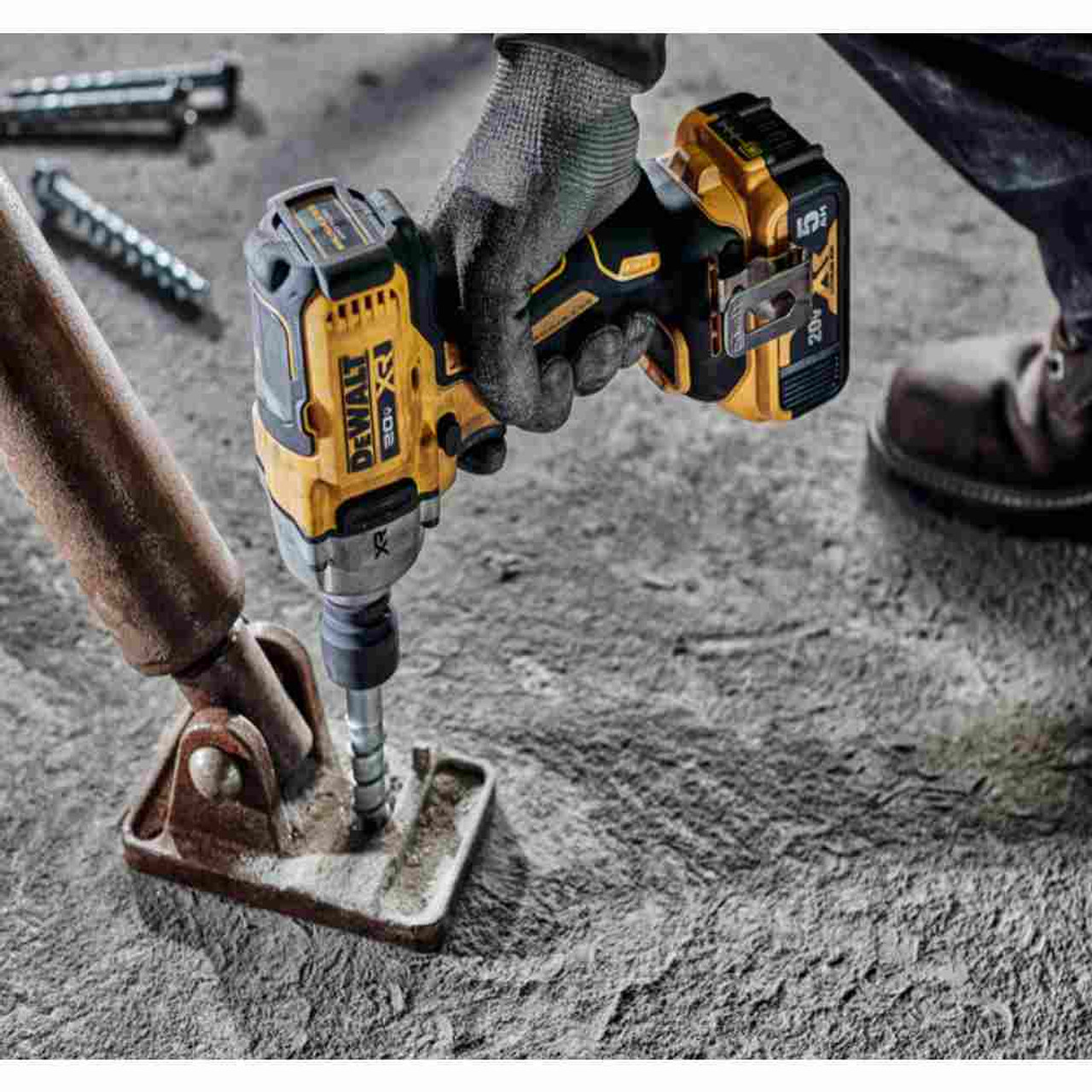 DeWalt DCF891P2 20V MAX XR Cordless Mid-Range 1/2 inch Impact Wrench with Hog Ring Kit showing in use fastening bolt through steel bracket into concrete floor