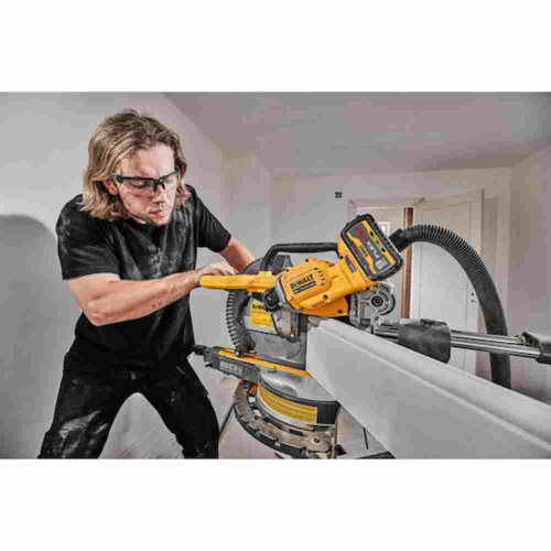DeWalt DCS781B 60V MAX 12 Inch Cordless Brushless Double Bevel Sliding Miter Saw (Tool Only) showing in use cutting base boards with saw on a miter (Battery sold separately)