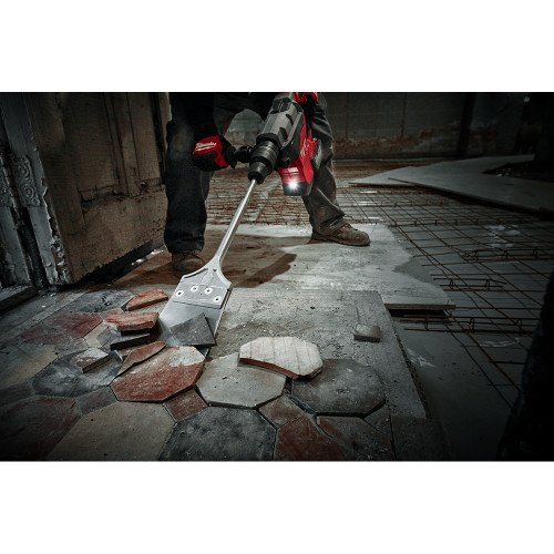Milwaukee 48-62-4096 6-inch x 25-inch SDS Max SLEDGE Floor Scraper showing in use scraping up floor tiles and glue