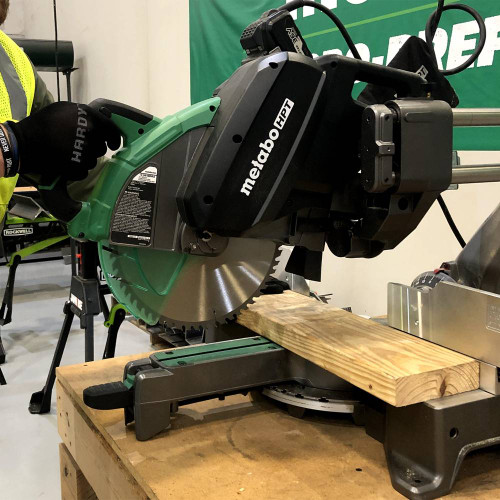 Metabo HPT C3612DRAQ4M 36V MultiVolt Cordless 12in Dual Bevel Sliding Mitre Saw (Tool Only) showing in use cutting wood stud (Battery sold separately)