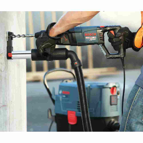 Bosch HDC100 SDS-Plus Dust-Collection Attachment showing in use drilling hole in a wall with vacuum attached (Sold Separately)