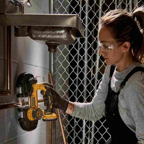 DeWalt DCS375B XTREME 12V MAX 1-3/4 inch Cordless Brushless Bandsaw (Tool Only) showing in use cutting copper pipe under sink using single handed