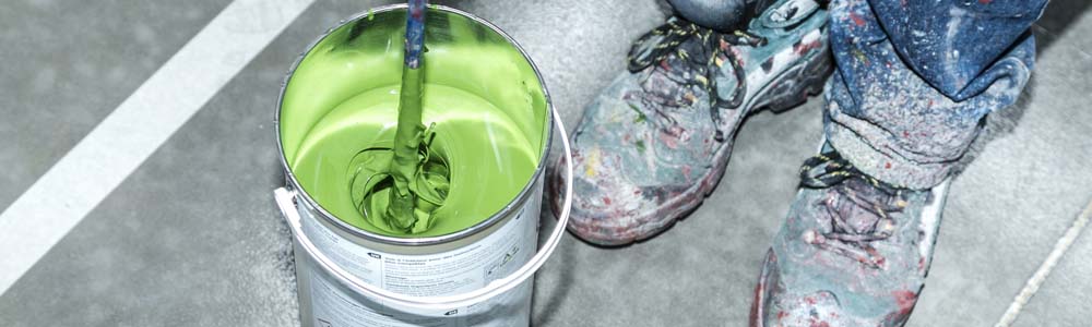 Maintenance worker mixing green epoxy resin paint | Watco Floors