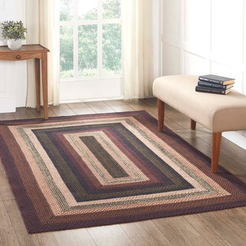 VHC Brands Beckham rectangle, jute braided rug, 60" x 96", in brick red, black, dark tan. Pictured on living room floor.