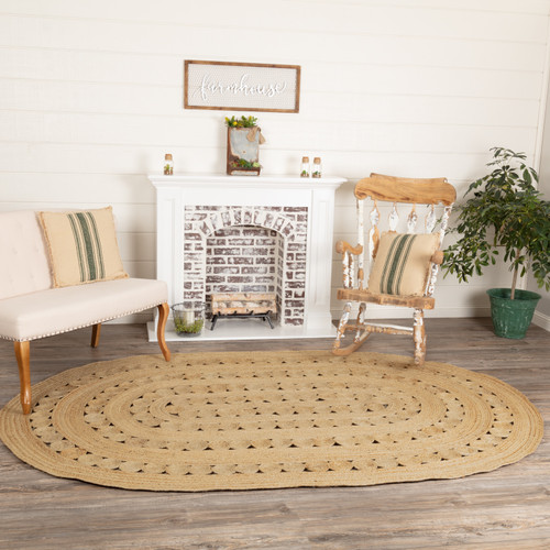 VHC Brands Celeste oval braided area rug, natural, 72" x 108", pictured in front of fireplace.