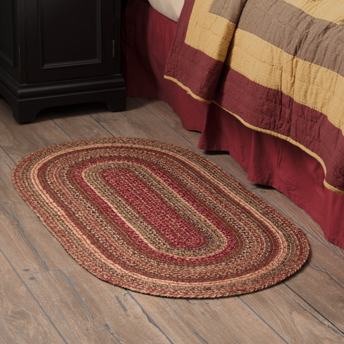 VHC Brands Cider Mill oval braided jute rug, 27" x 48", burgundy, black, tan, olive green, pictured by bedside.
