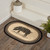 VHC Brands Sawyer Mill Charcoal Hog Print oval jute braided rug, 20" x 30", pictured at foot of staircase.