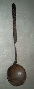 Primitive metal ladle with carving