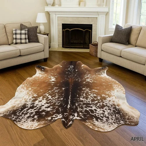 Brown and white cowhide rug on hardwood floor in cozy living room with fireplace
