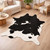 Black and white cowhide rug in modern living room with wood floor and cozy furniture