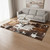 Brown and white cowhide patchwork rug in modern living room with sofa and coffee table