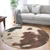 Round cowhide rug with brown, black, and white pattern in modern living room