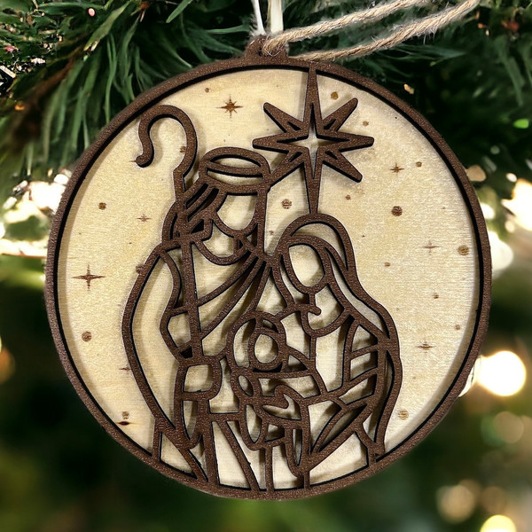 A wooden Christmas ornament with a laser-cut design of the Holy Family.