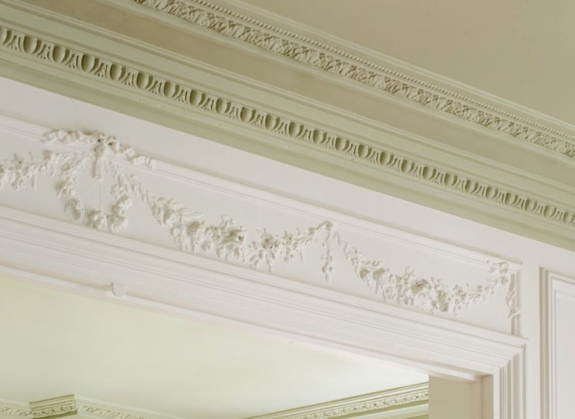 Close view of a floral swag under crown moulding