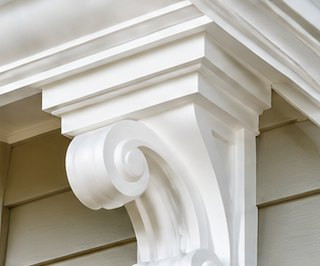 White scrolled corbel bracket under a porch eave