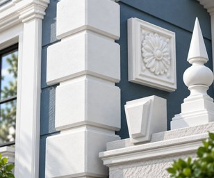 Cream stone-look quoins on the corner of a red brick wall