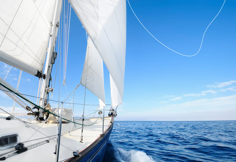 Een mooie foto van een zeilboot op de oceaan, met een blauw geschilderde romp.