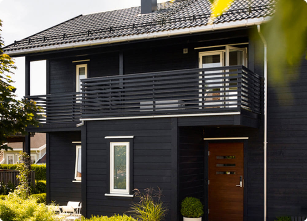 Dekkende Jotun beits op een houten woning met balkon.