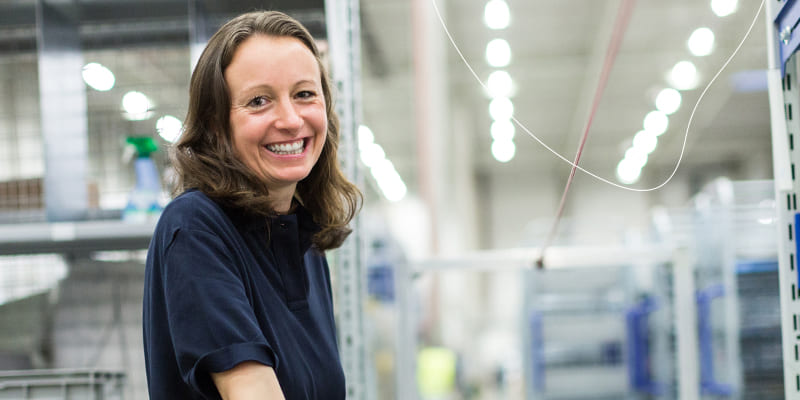 Een blije vrouw die aan het werk is bij Verf.nl.