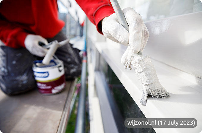 De schilder brengt de Wijzonol LBH SDT Ultra Hoogglanslak een witte verflaag aan op het kozijn.