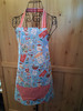 Hand‑Crafted Gingerbread and Sass apron displayed on a sewer’s mannequin, showing gingerbread houses, candy canes, rolling pins, and holiday baking motifs