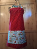 “Red mushroom‑cap polka dot apron with whimsical blue gnome‑meadow pocket”