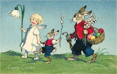 vintage easter postcard with child leading two rabbits carrying basket of eggs across spring meadow